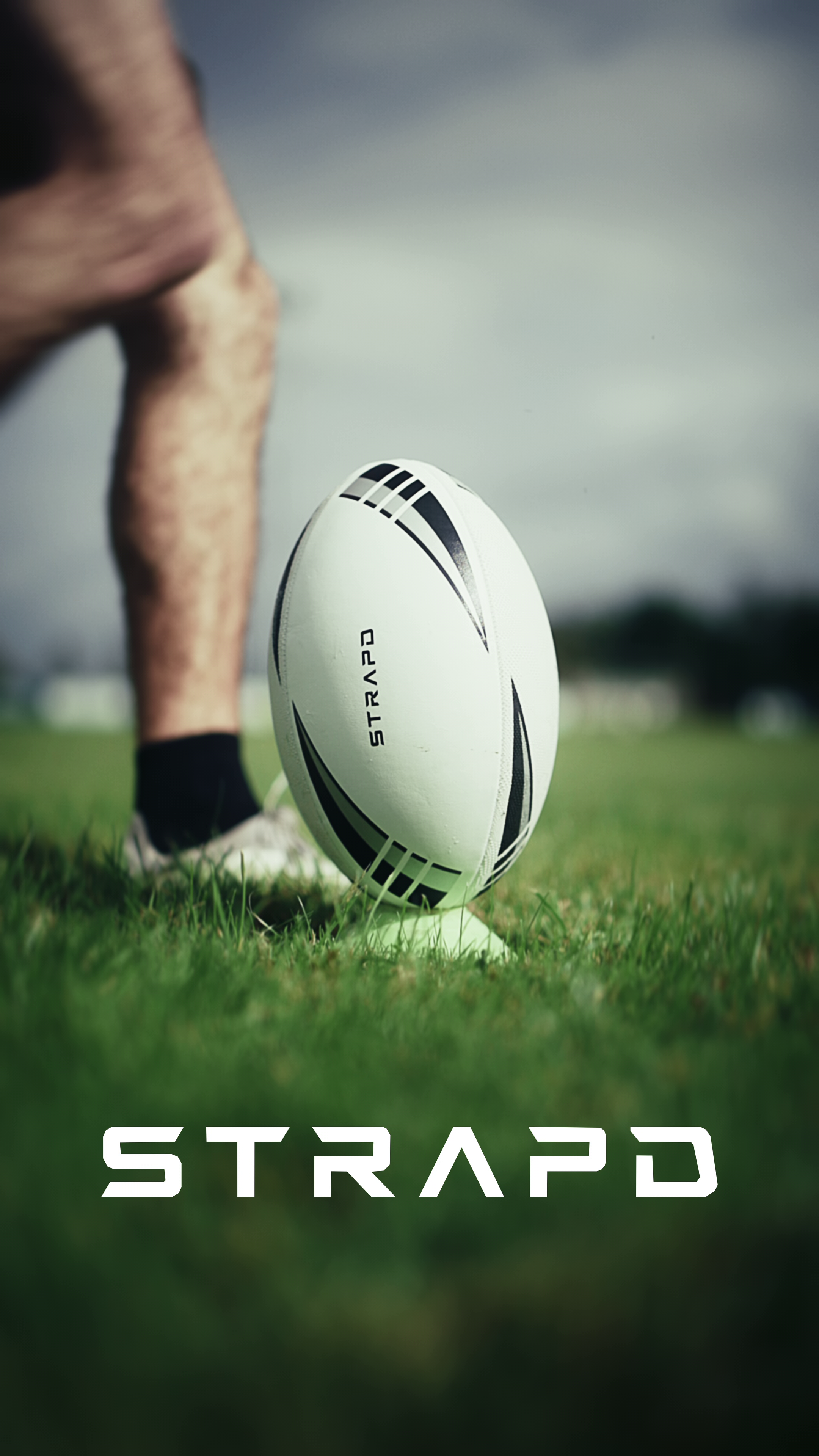 STRAPD rugby ball on the pitch, with the brand name set across the lower frame