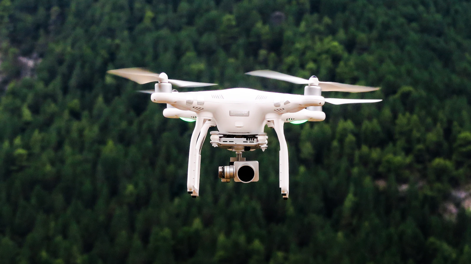 Drone with camera flying above a forest